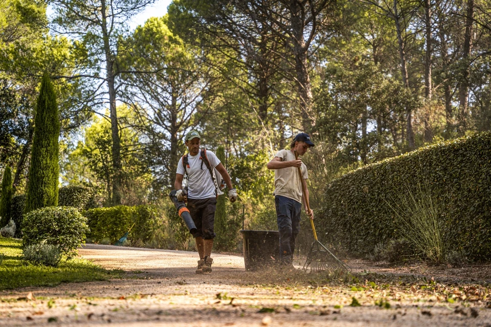 Chantier extérieur de construction d'une terrasse en bois dans jardin résidentiel clôturé